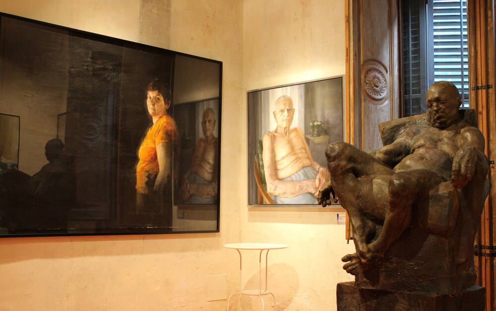 LE MEAM: Tableau à gauche : José Carlos Naranjo Bernal, « La Perla », 2011 ; tableau au centre : Carlos Asensio Sanagustin, « L’avi » (Le grand-père), 2010 ; sculpture : Grzegorz Gwiazda, « Sitting man », 2011